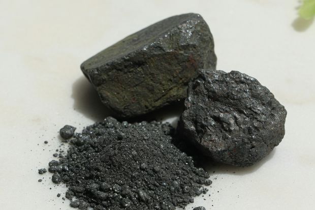 Kleine silbrig glänzende Metallstücke auf Marmor